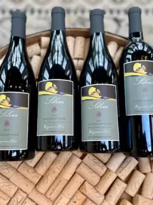 wine bottles on a cork topped wine barrel