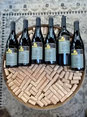 6 bottles on top of a wine barrel